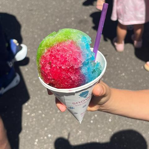 A rainbow snow cone held up at an event